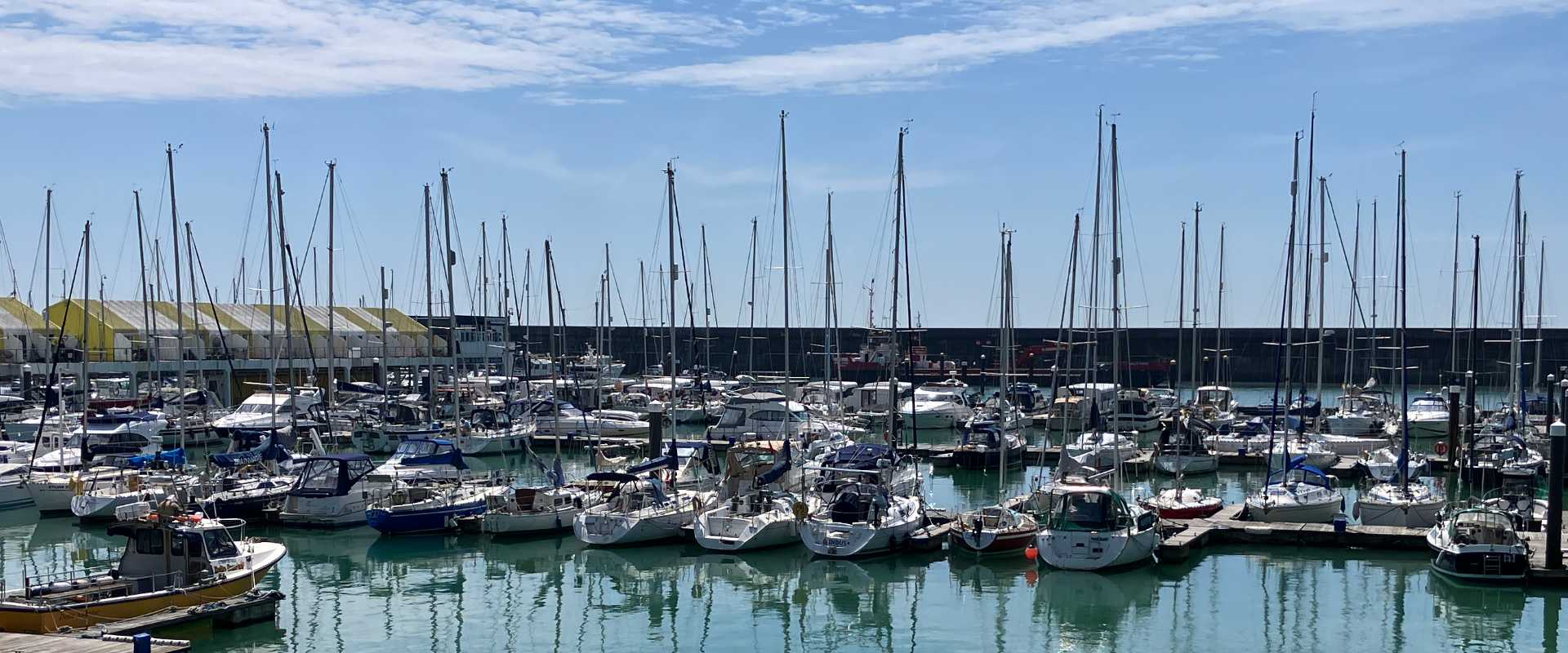 image shows sail boats lined up in Brighton Marina