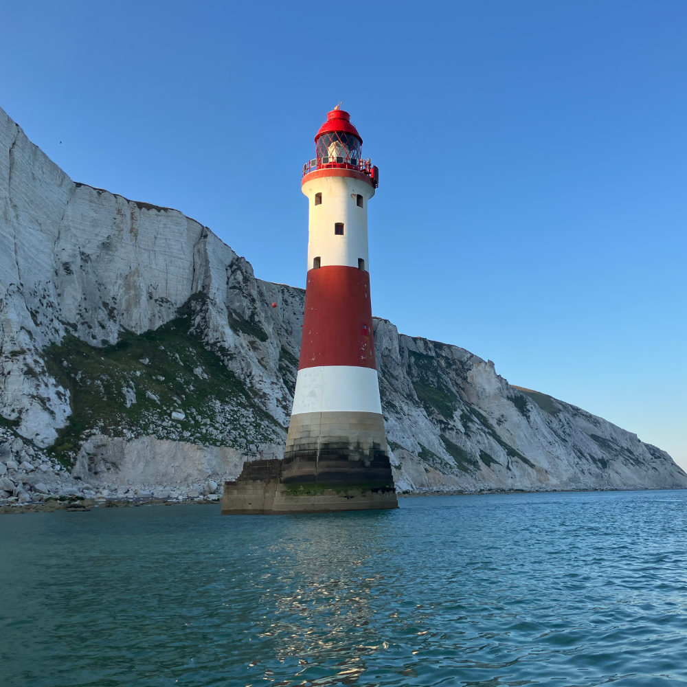 image shows Beachy Head Lighthouse from the water 