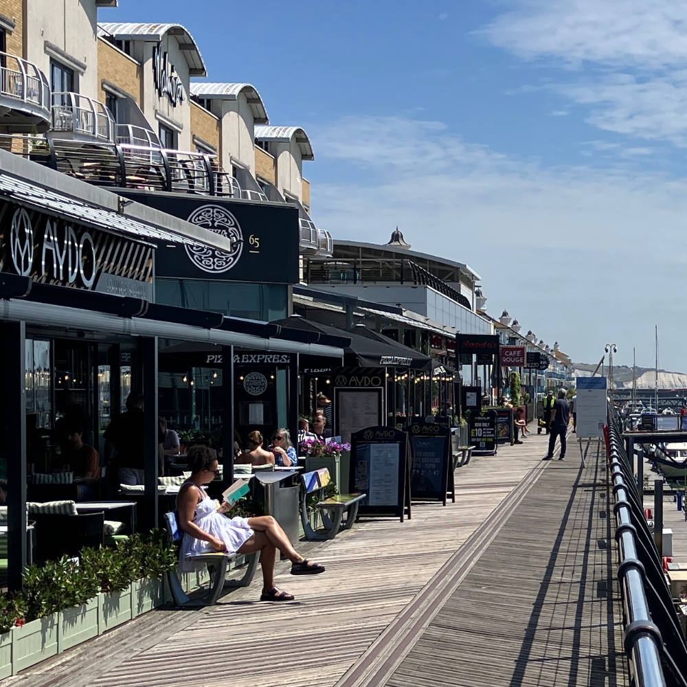 Photo Shows a wooden walkway at Brighton Marina and the various eateries being used.