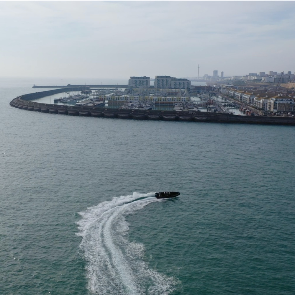 image shows powerboat demonstrating a high speed manoeuvrer with brighton marina in the background  