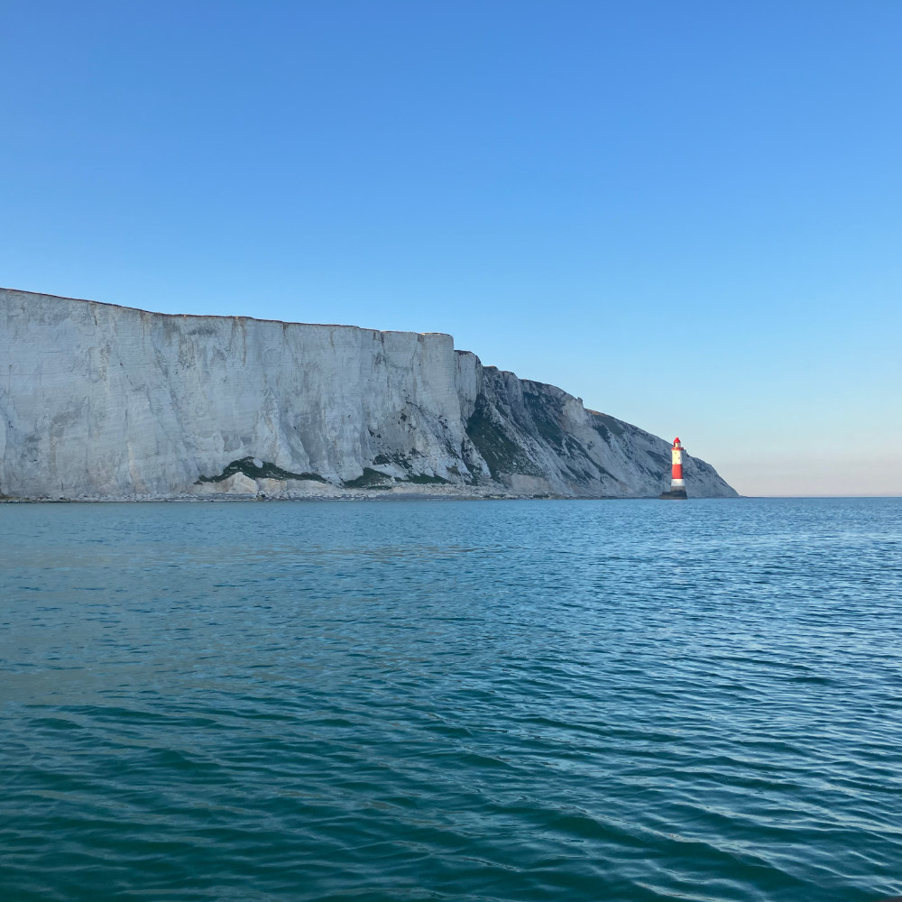 beachy head lighthouse with white cliffs in the background 