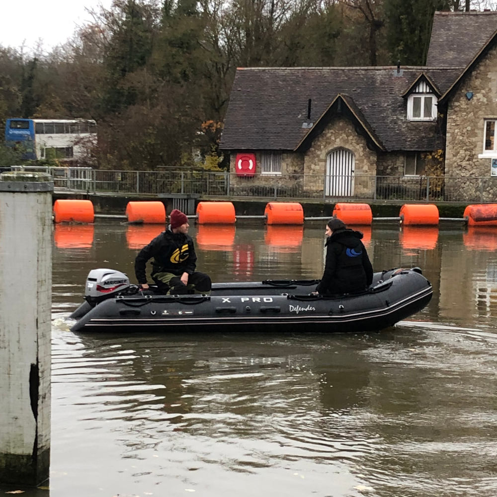 Commercial Safety Boat operating in a river running through a town.