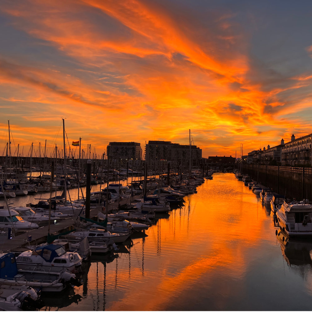 Brighton Marina illuminated by a picturesque sunset with the boats floating on golden waters